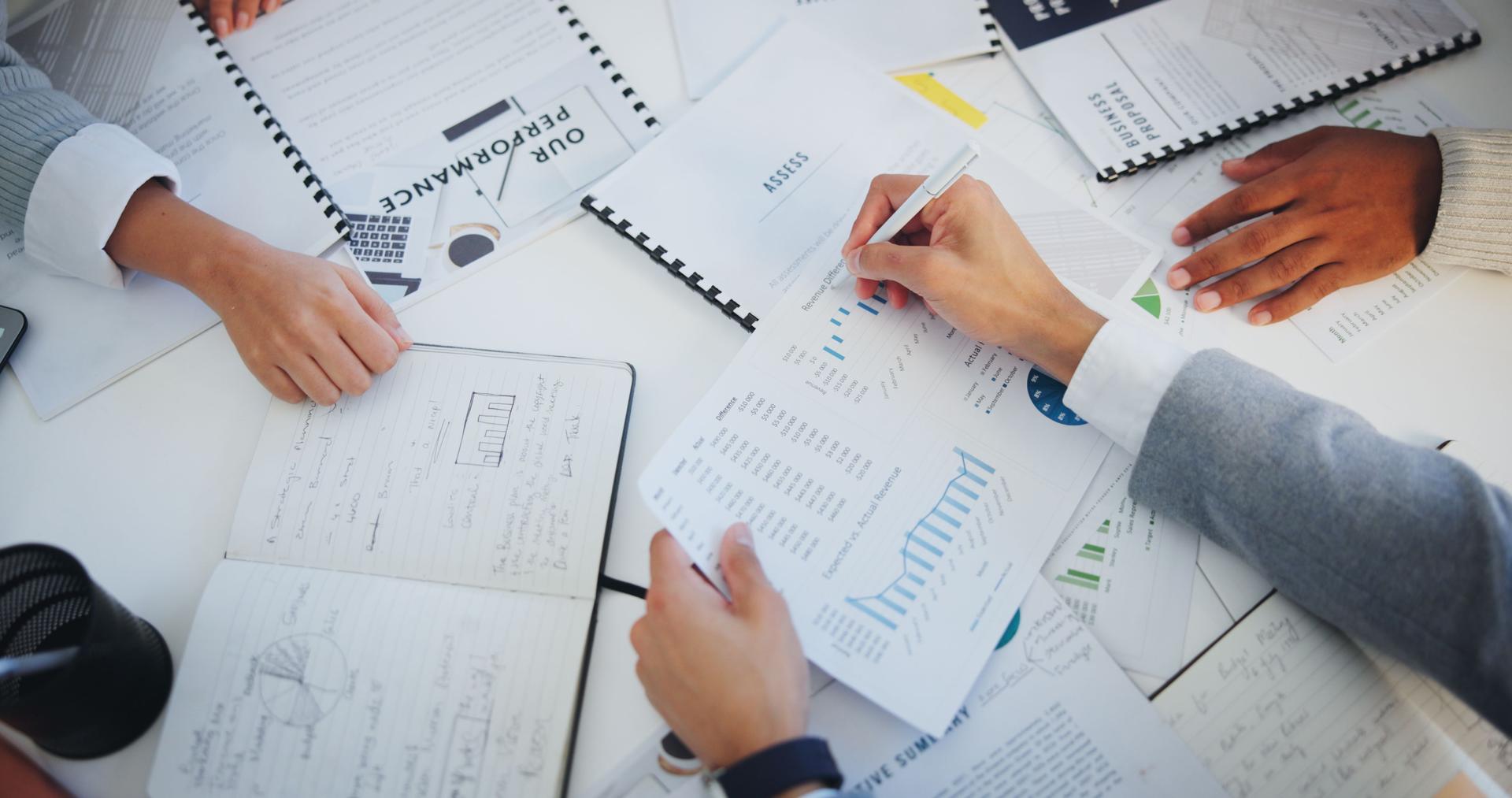 Hands, business people and group with documents, above and circle with writing, graphs or notes for finance. Staff, audit and performance review for stats, charts or notebook with paperwork in office